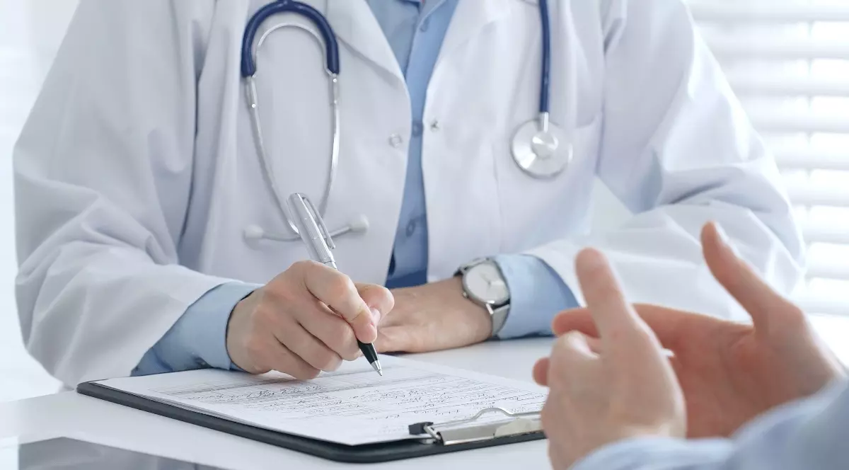 Un medic și un pacient care discută în cabinet, în timpul unei consultații