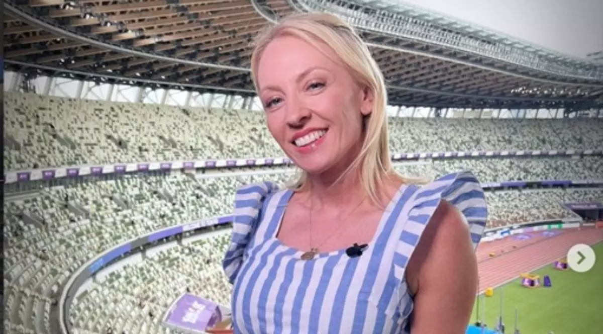 Jurnalista BBC Natalie Pirks , pe un nstadion, cu o bluza cu dungi albe -albastre