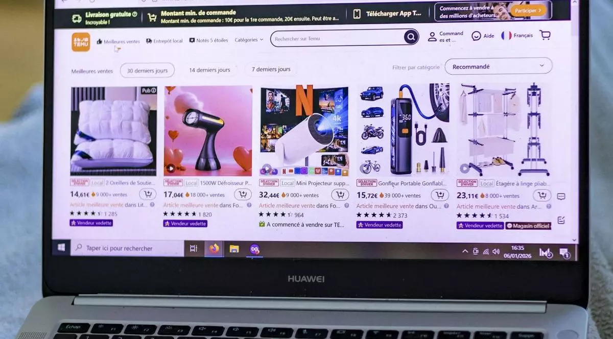 O tânără fată întinsă pe o canapea sub o pătură se uită la un magazin online pe laptopul ei, platforma de comerț electronic Temu