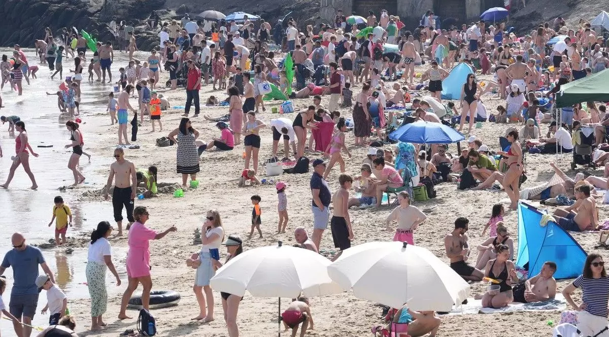 Oameni care se bucură de vremea caldă pe plaja Sunny Sands din Folkestone, Kent. Temperaturile în anumite părți ale Regatului Unit ar putea fi mai ridicate decât în ​​Seychelles. Foto Profimedia