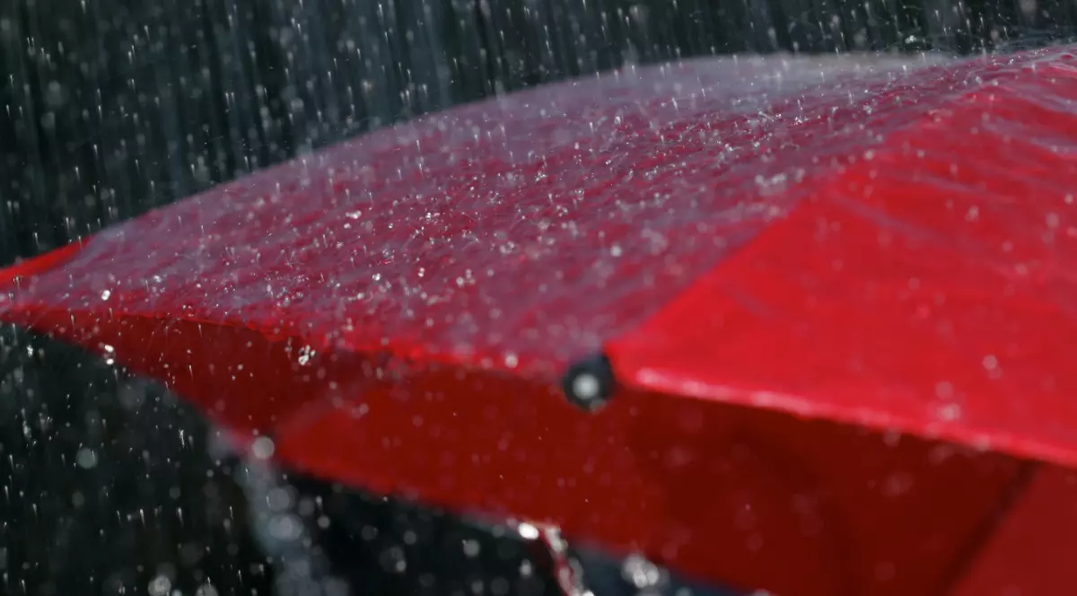 Ploaie torențială cade pe o umbrelă roșie