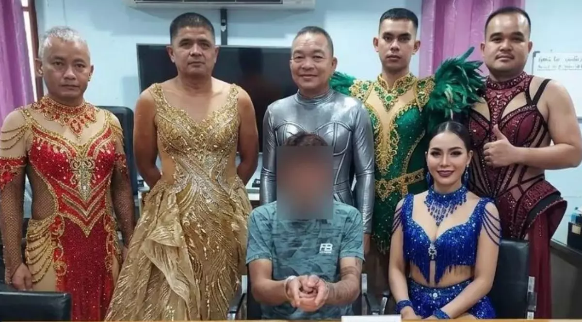 Un grup de bărbați care poartă rochii colorate și strălucitoare cu pene și paiete. Bărbații stau în spatele unui individ care poartă cătușe și este suspectat de trafic de droguri