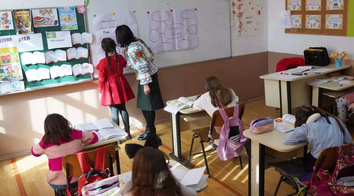 O profesoară este în clasă cu mai mulți elevi