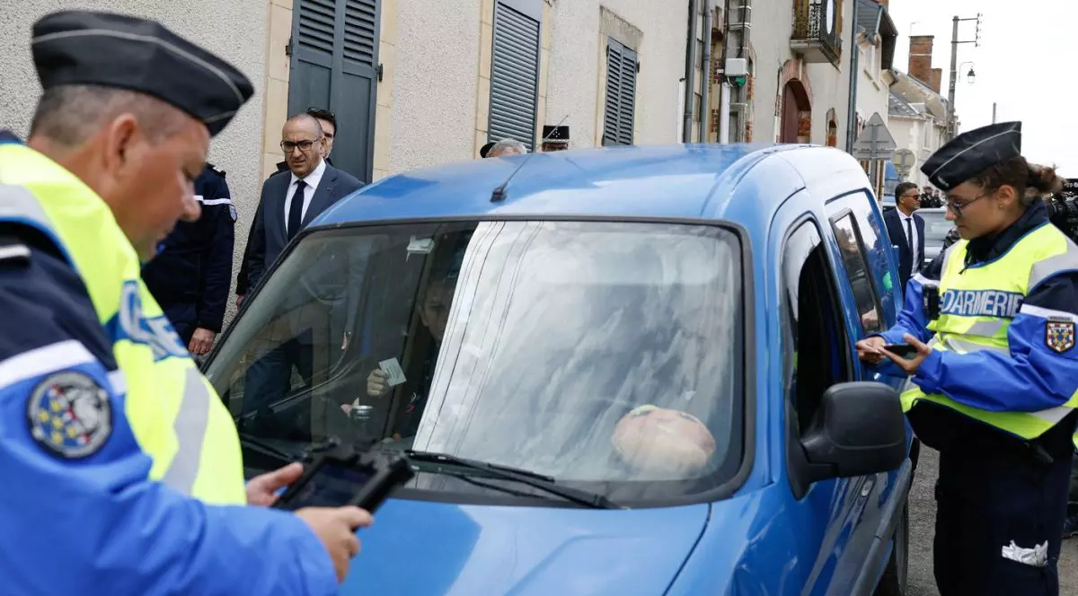 Doi ofițeri de poliție dau amendă unui șofer pe o stradă din Cornusse, Franța, 3 mai 2026