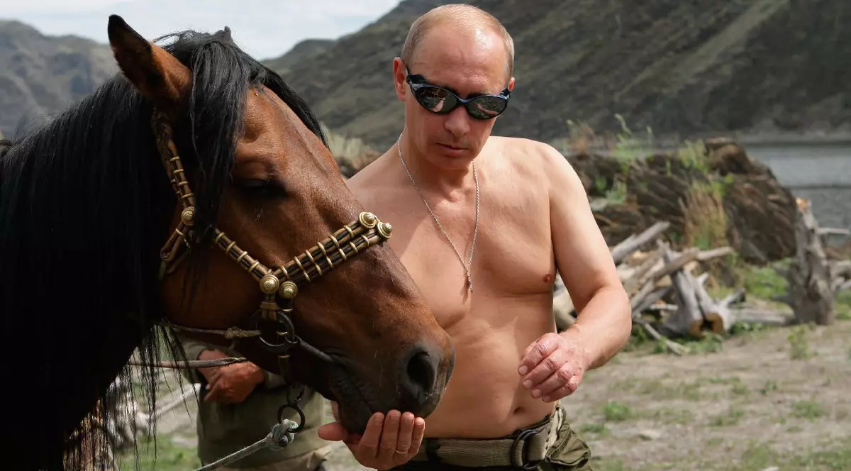 Vladimir Putin, la bustul gol, ținând un cal de hățuri