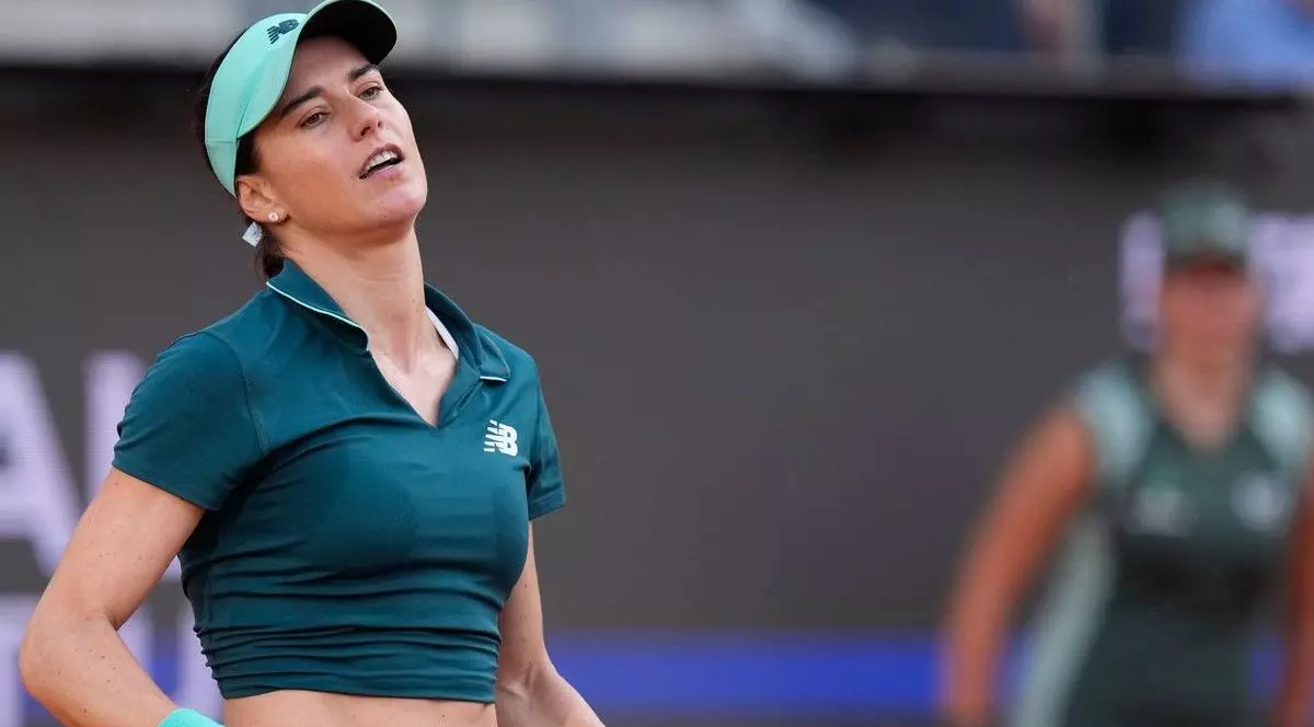 orana Cîrstea, cu tricou verde inchis si sepcuta verde deschis, face un gest larg cu mainile pe terenul de tenis