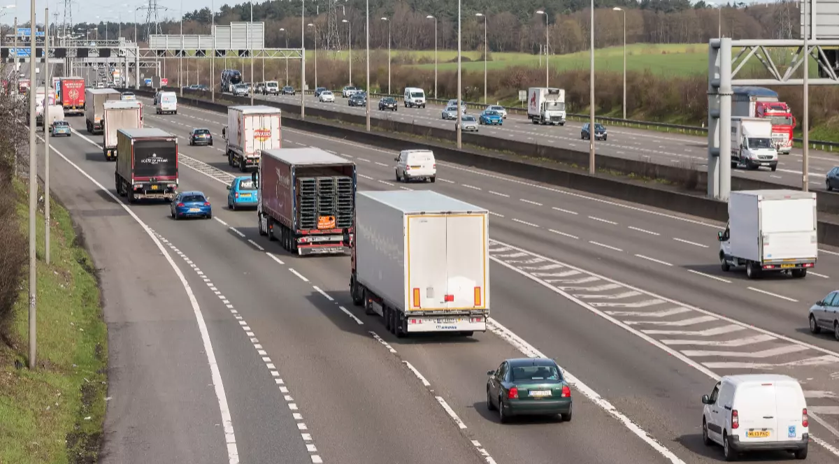 Imaginea prezintă trafic aglomerat pe o autostradă cu mai multe benzi de circulație pe sens.