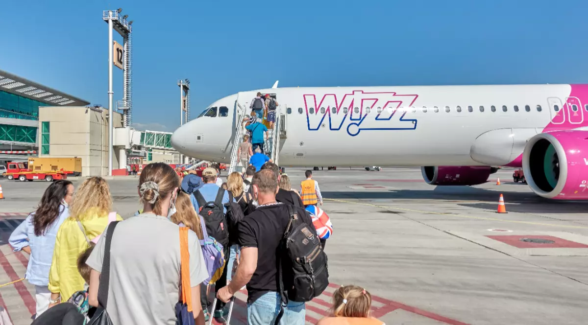 Mai mulți turiști care se urcă într-un avion Wizz Air de pe un aeroport
