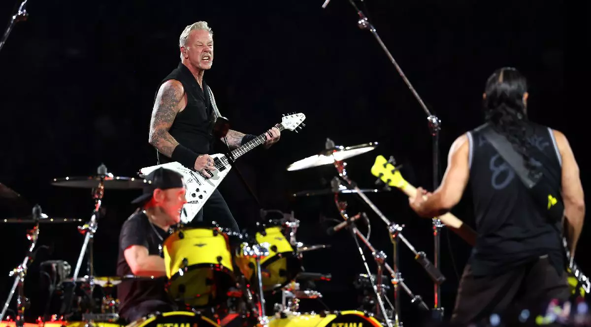 Lars Ulrich, James Hetfield și Robert Trujillo de la Metallica, pe scenă, în timpul unui concert.