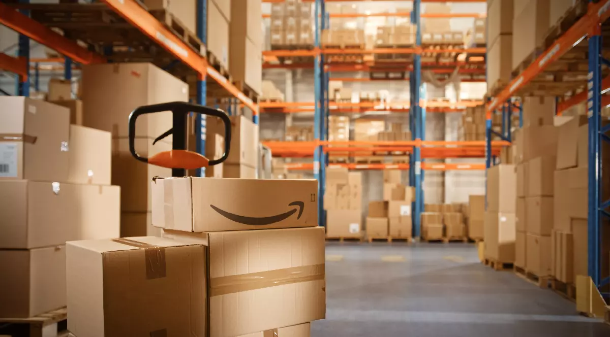 Un depozit în care se află pachete care conțin logo-ul Amazon
