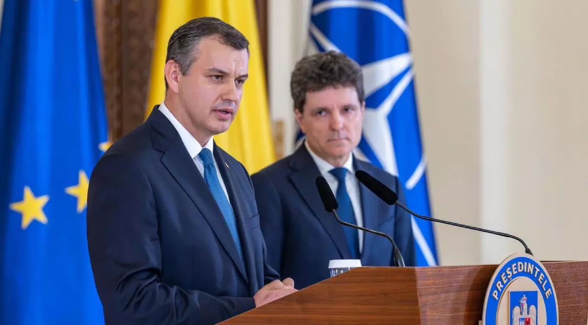 Eugen Tomac, îmbrăcat în costum negru și cravată albastră, la Palatul Cotroceni, și Nicușor Dan, președintele României, îmbrăcat în costum și cravată albastră, iar pe fundal steagurile României, UE și NATO