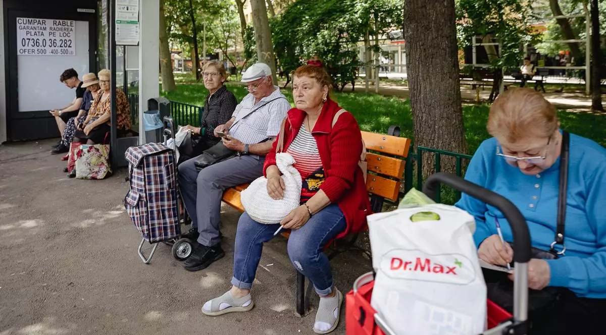 Pensionari asteapta autobuzul intr-o statie