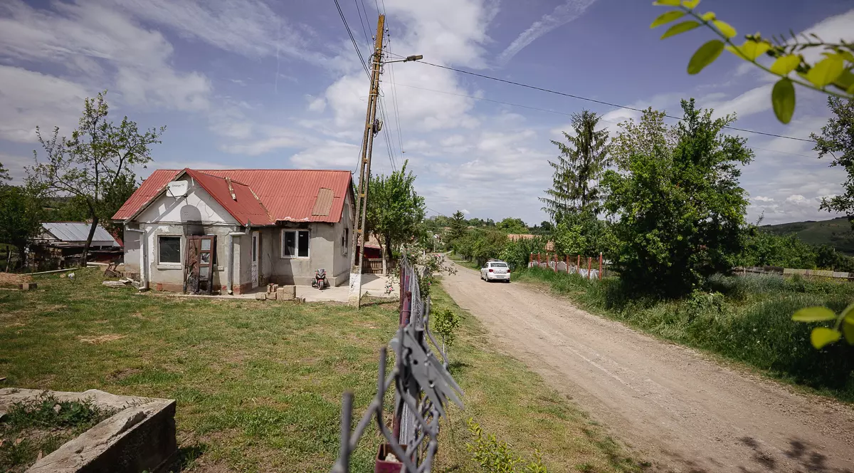 Imagine dintr-un sat, drumul cu o masina de politie si o casa