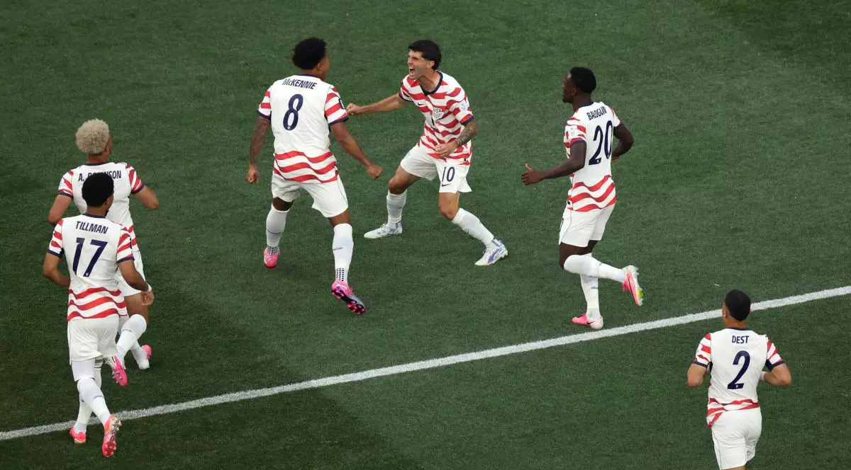 INGLEWOOD, CALIFORNIA - JUNE 12: Christian Pulisic #10 and Weston McKennie #8 of the United States celebrate their side's first goal, an own goal by Damian Bobadilla #16 of Paraguay (not pictured), during the FIFA World Cup 2026 Group D match between USA and Paraguay at Los Angeles Stadium on June 12, 2026 in Inglewood, California. (Photo by Harry How/Getty Images)