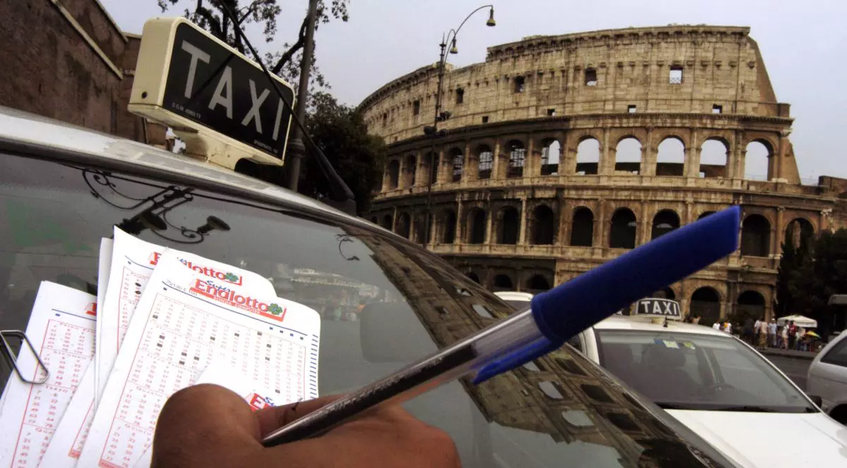Un șofer de taxi selectează numere pentru a juca la principala loterie a Italiei, cunoscută sub numele de SuperEnaLotto, în fața Colosseumului, pe 13 august 2003, la Roma, Italia