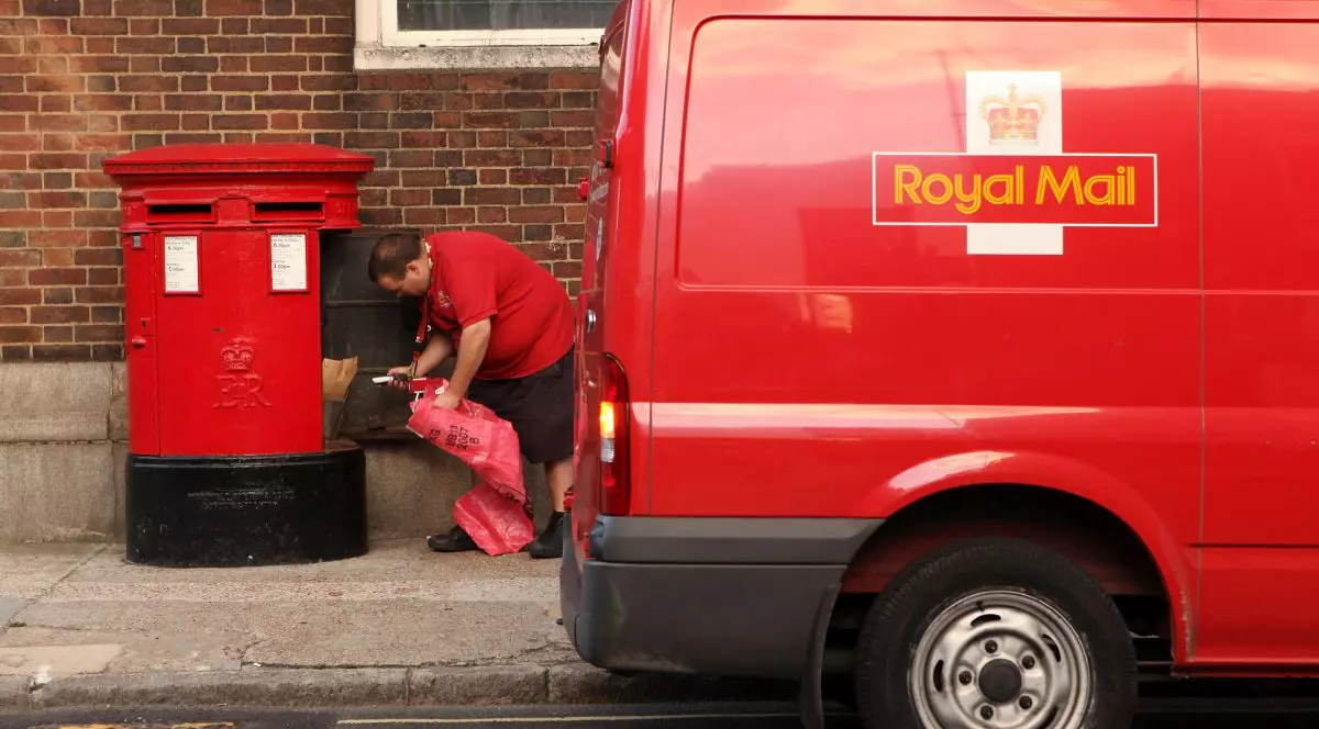 Un angajat al Royal Mail golește o cutie poștală în Southwark, pe 16 octombrie 2009, la Londra, Anglia