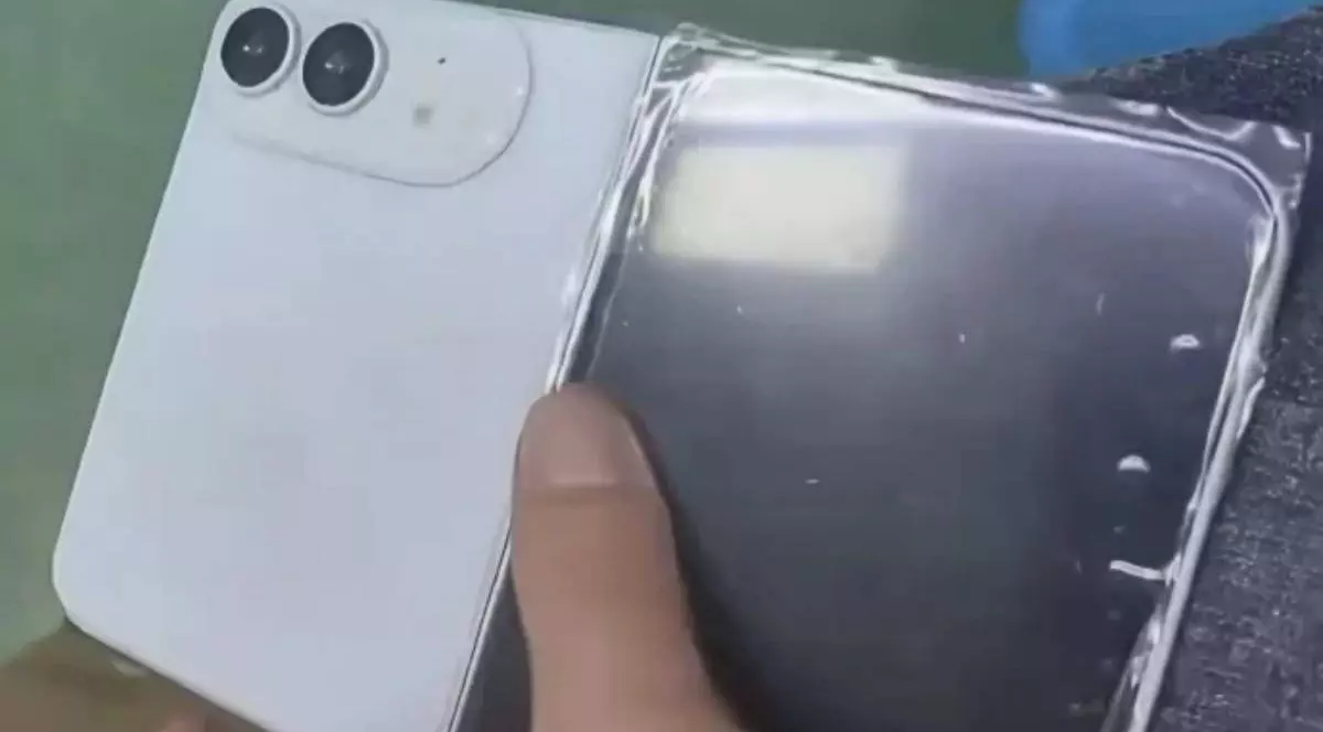 O machetă iPhone Ultra, de culoare albă, ținută în mână în poziția depliată.