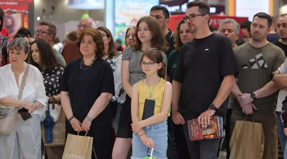 Mai mulți oameni, cu cărți în mână sau pungi Litera, participă la lansarea cărții Gutenberg 42, la Bookfest