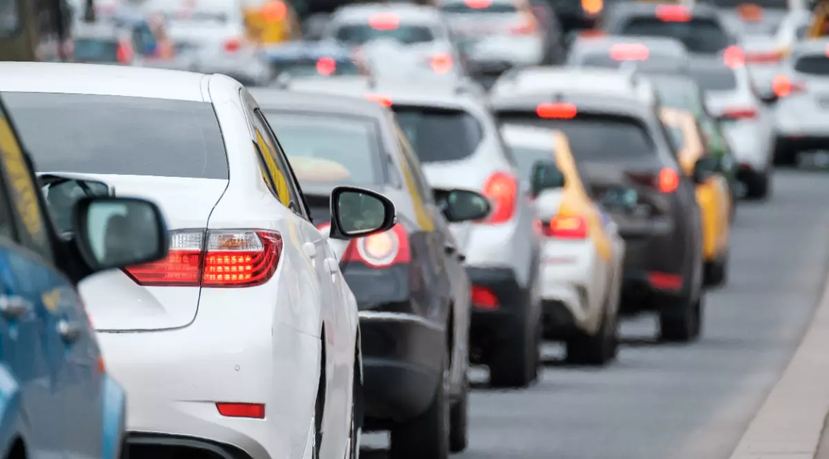O coloană de autoturisme surprinse din spate în timp ce înaintează bară la bară în traficul urban.