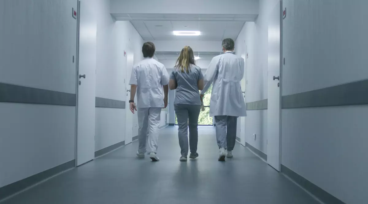 Trei doctori care merg pe coridorul unui spital