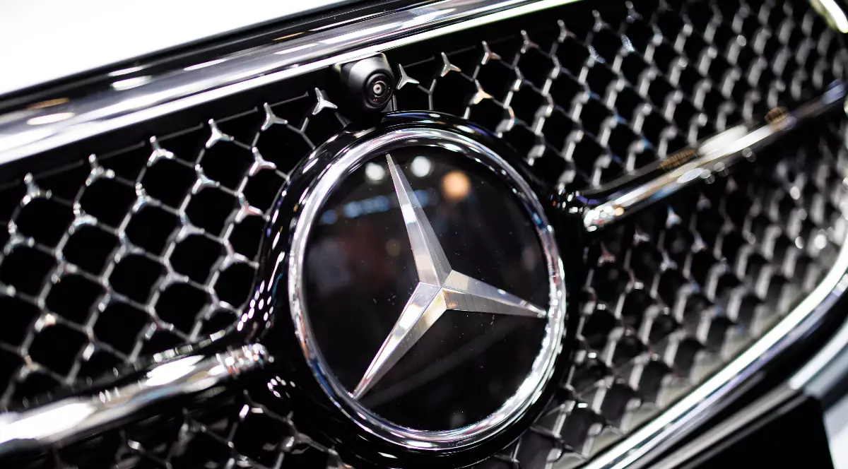 Prim-plan cu sigla mărcii Mercedes-Benz pe grila din față a unei mașini Mercedes