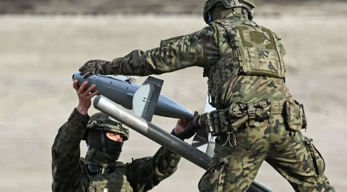 Doi militari îmbrăcați în uniform de camuflaj manevrează un interceptor din sistemul anti-dronă Merops