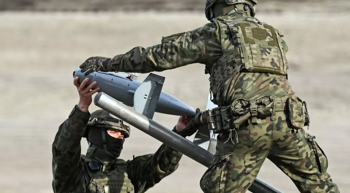 Doi militari îmbrăcați în uniform de camuflaj manevrează un interceptor din sistemul anti-dronă Merops