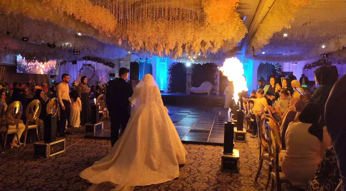 O sală de nuntă elegantă, cu mirii în prim-plan, invitați numeroși și o atmosferă spectaculoasă, exact genul de imagine care susține ideea unei petreceri de amploare. În plus, efectele pirotehnice și decorul impresionant transmit vizual mesajul din titlu despre o nuntă atât de intensă încât „niciun italian nu a supraviețuit până la sfârșit