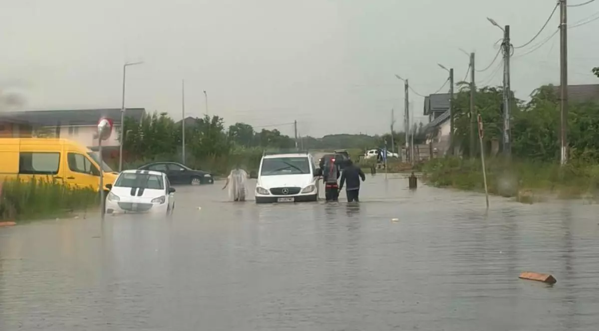 Oameni și mașini care au fost inundate în urma ploilor.