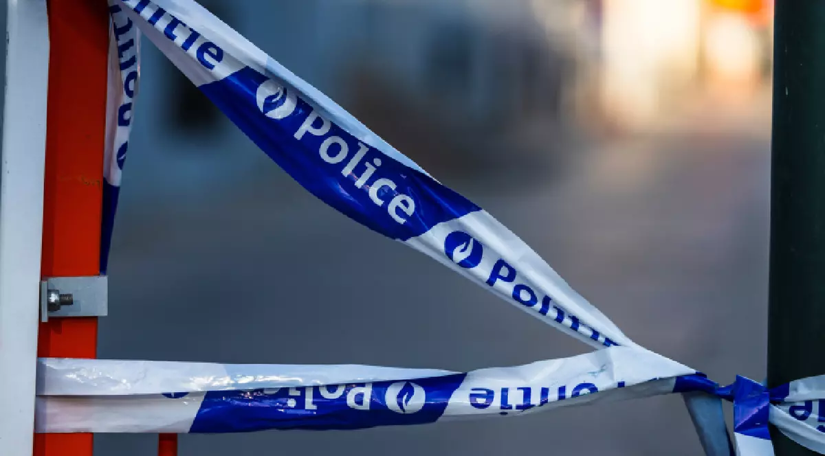 Bruxelles Belgia 2025-07-11 Detaliu cu o bandă adezivă de tip barieră a poliției belgiene albastre și albe, cu cuvintele „Politie” și „Police” imprimate pe ea, legate între un stâlp de metal și o barieră.