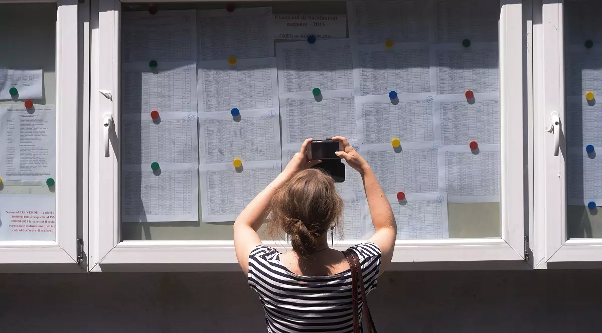 Rezultate BAC Botoșani 2026 Foto:Hepta - O elevă fotografiază listele cu notele de la Bacalaureat afișate la avizieruldin curtea liceului