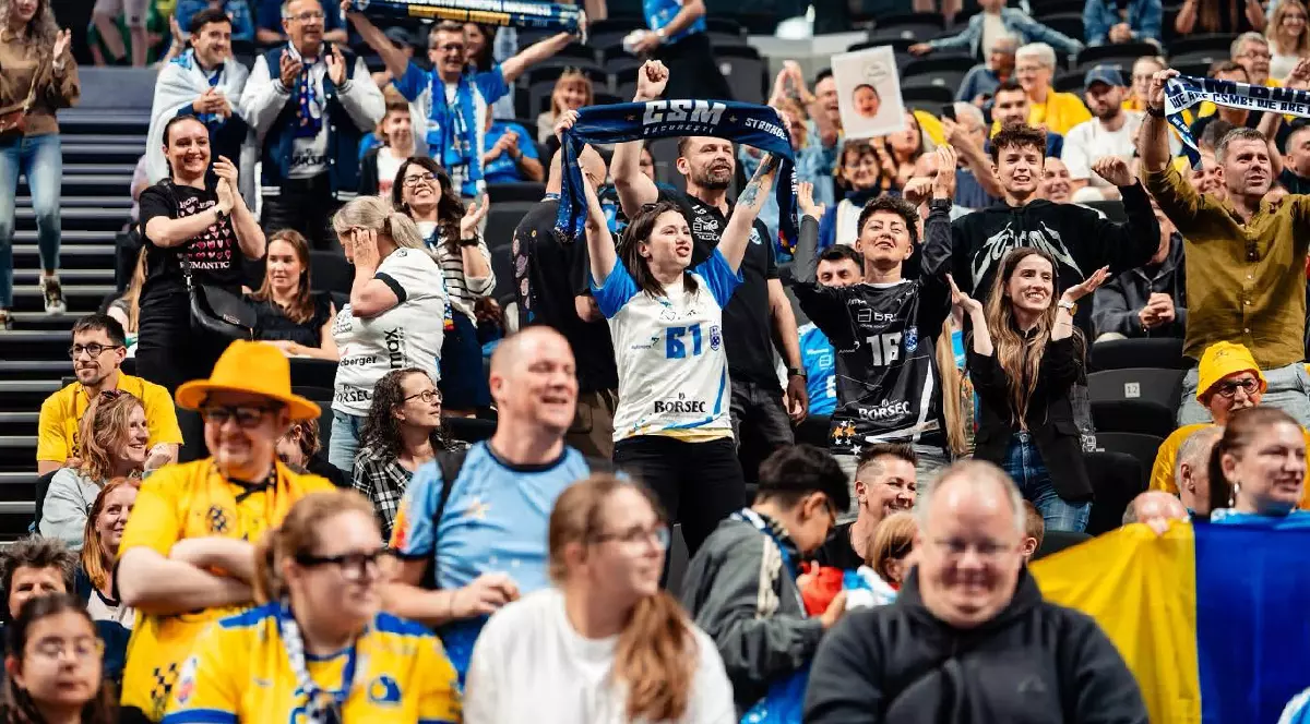 Suporteri ai echipei CSM București în tribună, în timp ce își susțin echipa favorită