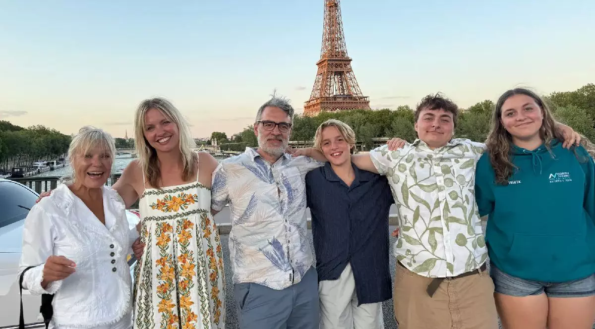 O familie cu 4 copii adolescenți si pe fundal Turnul Eiffel
