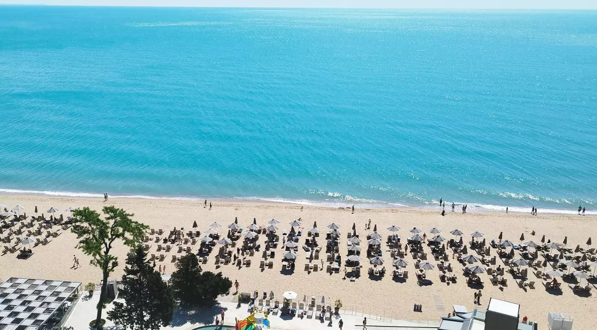 o plaja de lqa Nisipurile de Aur, Bulgaria, plaja cu sezlonguri si o apa turcoaz