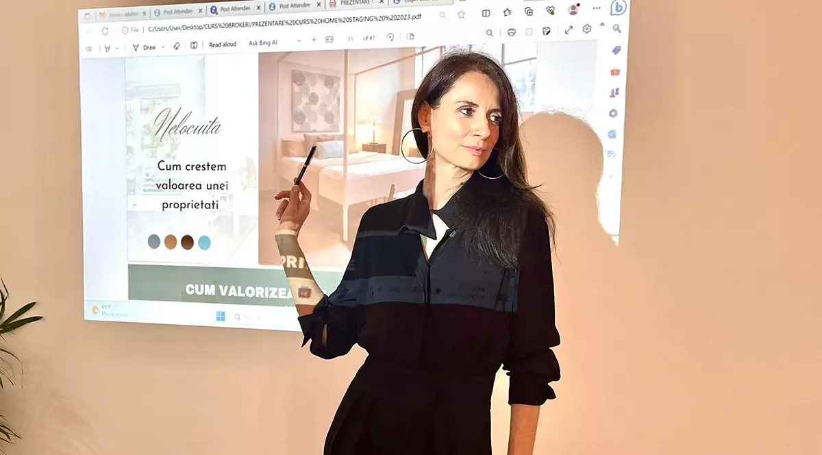 Adriana Popescu în fața unei prezentări îmbrăcată toată în negru.