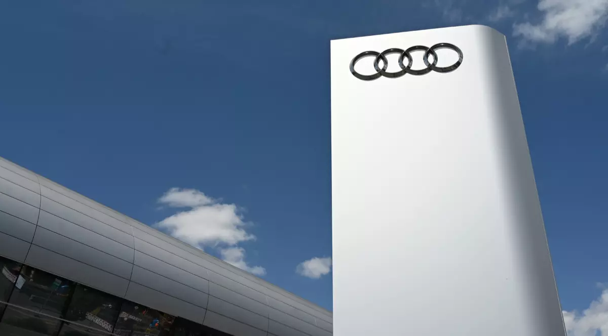 Logo-ul Audi pe o suprafață gri metalizată.