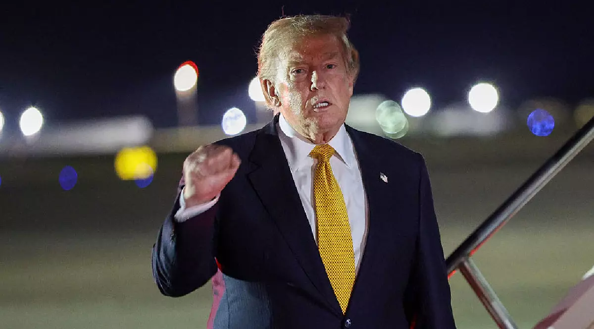 Președintele SUA, Donald Trump, face un gest în timp ce coboară din Air Force One pentru a urca la bordul noului avion Boeing, cadou din partea Qatarului, în drumul său spre Statele Unite, după participarea la summitul NATO de la baza Royal Air Force Mildenhall, pe 8 iulie 2026, în Mildenhall, Anglia.
