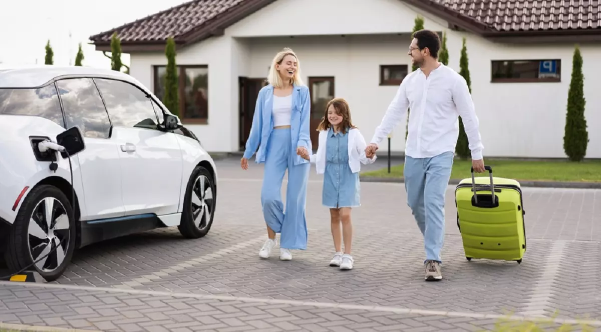 Cum să îţi planifici concediul şi cum să călătoreşti cu maşina electrică - Imagine cu o tânără familie formată din soţ soţie şi un băiat care se pregăteşte să plece intr-o călătorie cu maşina electrică