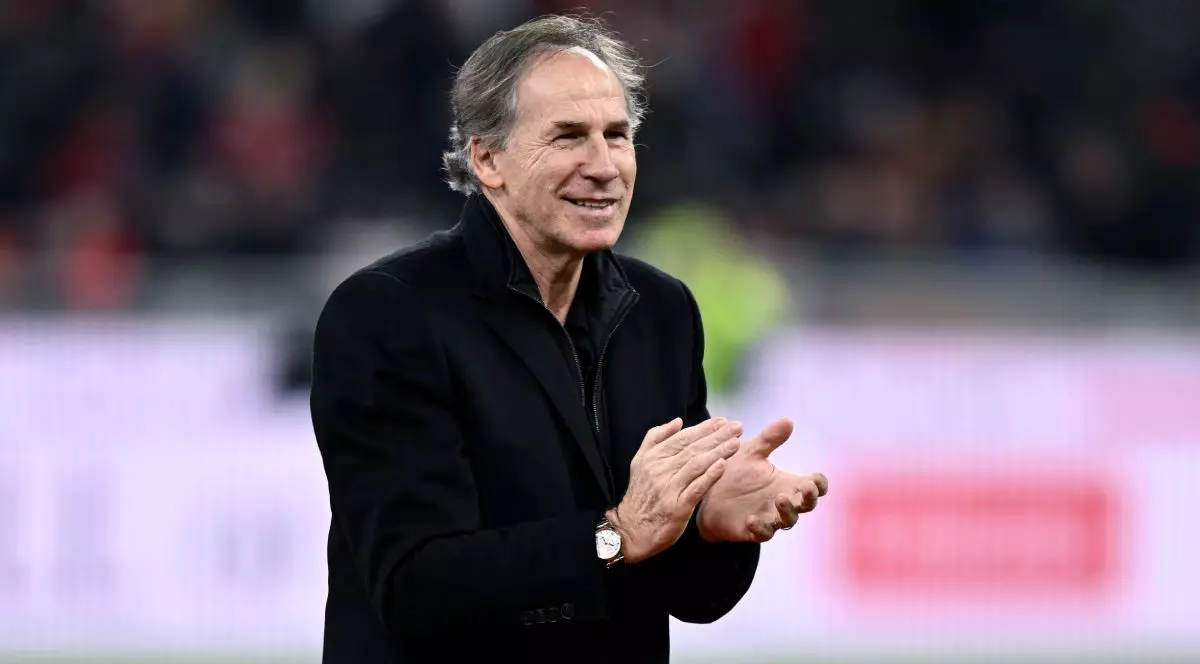 Franco Baresi, îmbrăcat cu un palton lung de culoare neagră, pe un teren de fotbal, în timp ce aplaudă