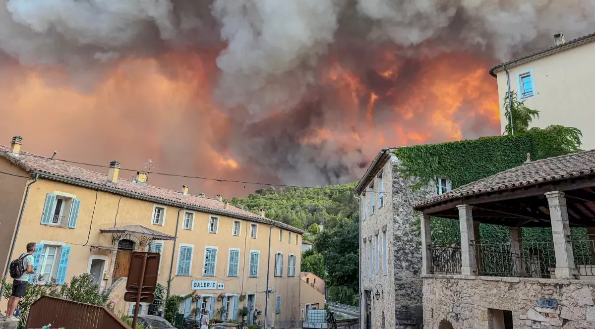 Un incendiu major de vegetație și un nor uriaș de fum se vede în apropierea unor case din Franța