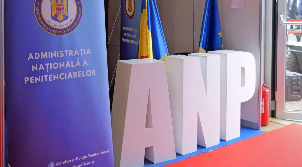 Logo al Administrației Naționale a Penitenciarelor, la intrarea într-o clădire, cu un stingător de incendii la ușă