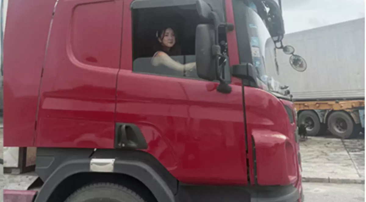 O femeie care se află la volan, în cabina unui TIR