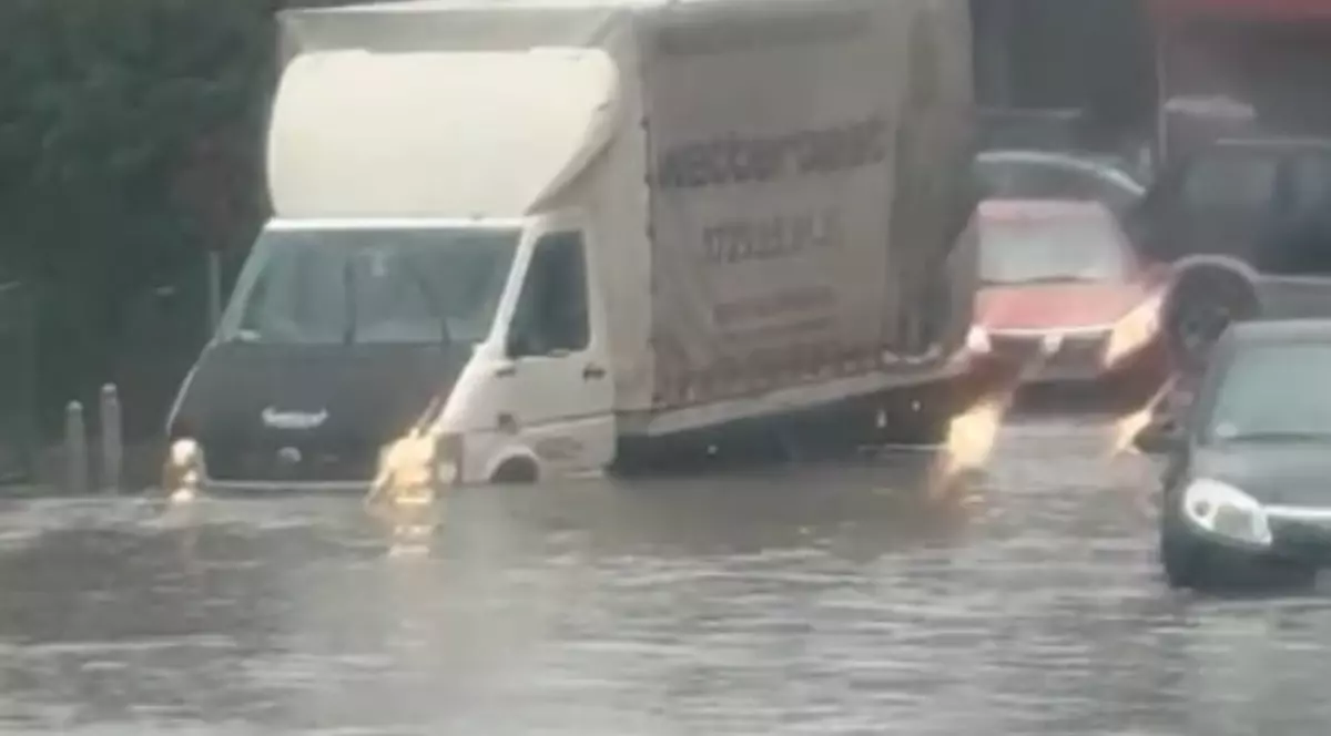 Mai multe mașini pe o șosea inundată.