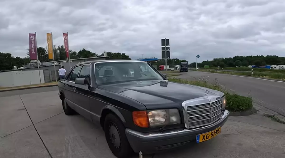 Un Mercedes 560 SE gri, într-o parcare