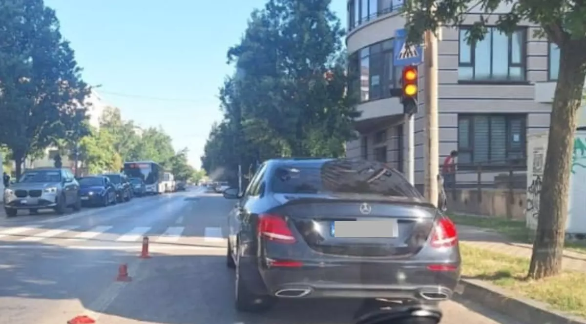 O mașină neagră parcată la semafor