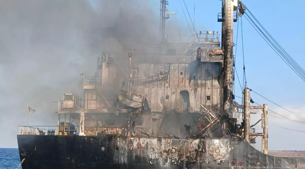 Imaginea arată o navă grav avariată, cu urme evidente ale unui incendiu puternic.