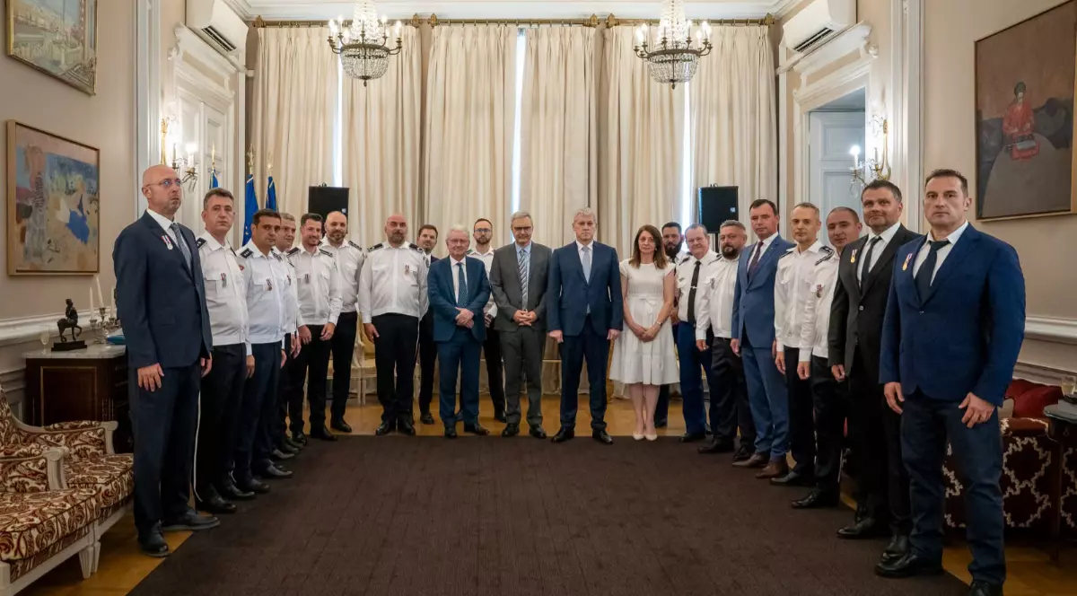 Un grup de polițiști alături de Ministrul Afacerilor Interne, la Ambasada Franței, stau așezați la poză