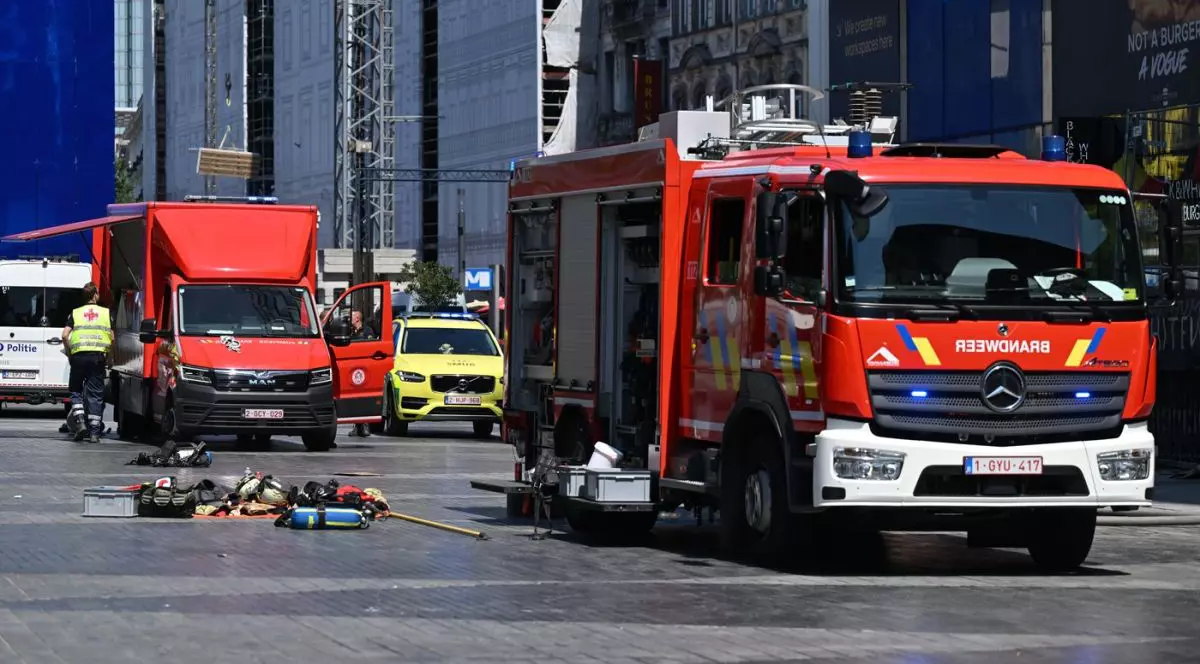 Două mașini de pompieri staționează lângă clădirea OXY din Place de Brouckère, Bruxelles, unde a izbucnit un incendiu, marți, 14 iulie 2026