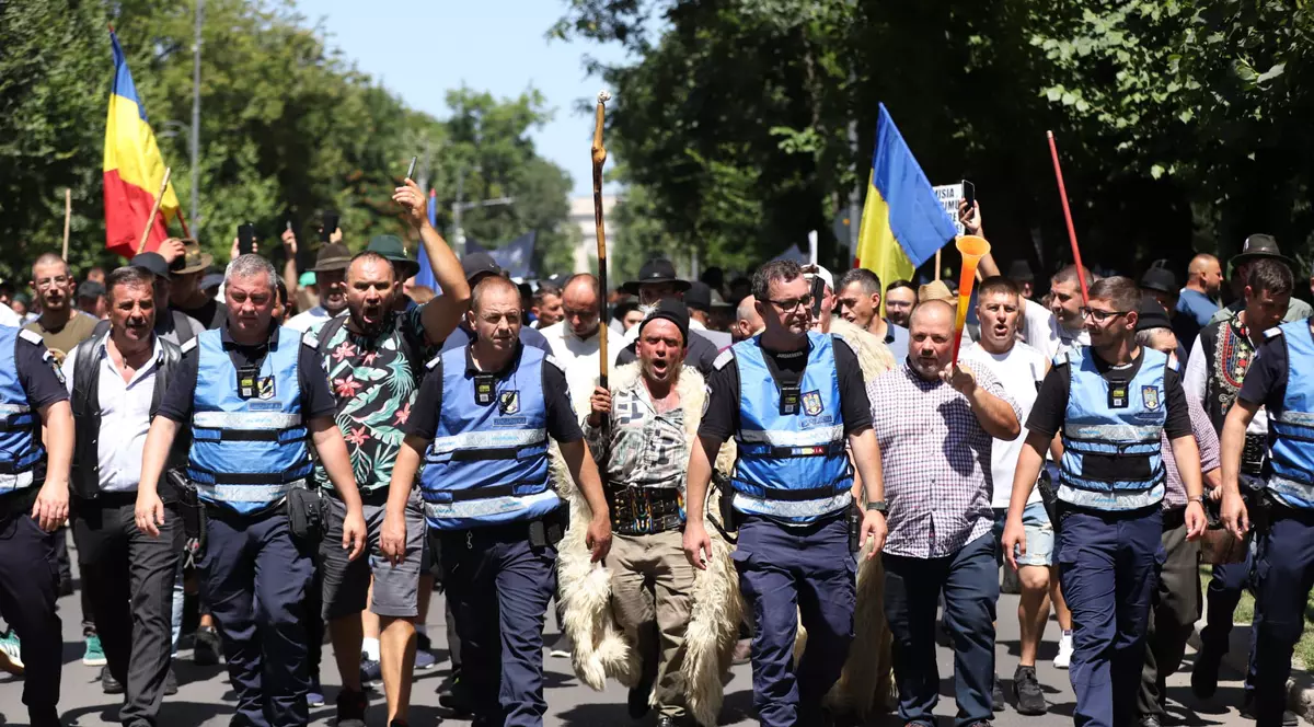 Mai multi fermieri incadrati de jandarmi protesteaza pe o strada din Bucuresti