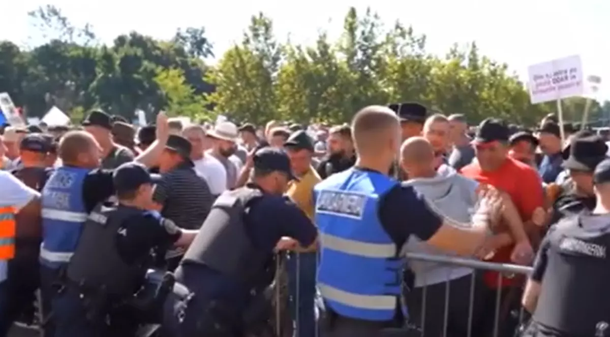 Jandarmi și oameni adunați la protest